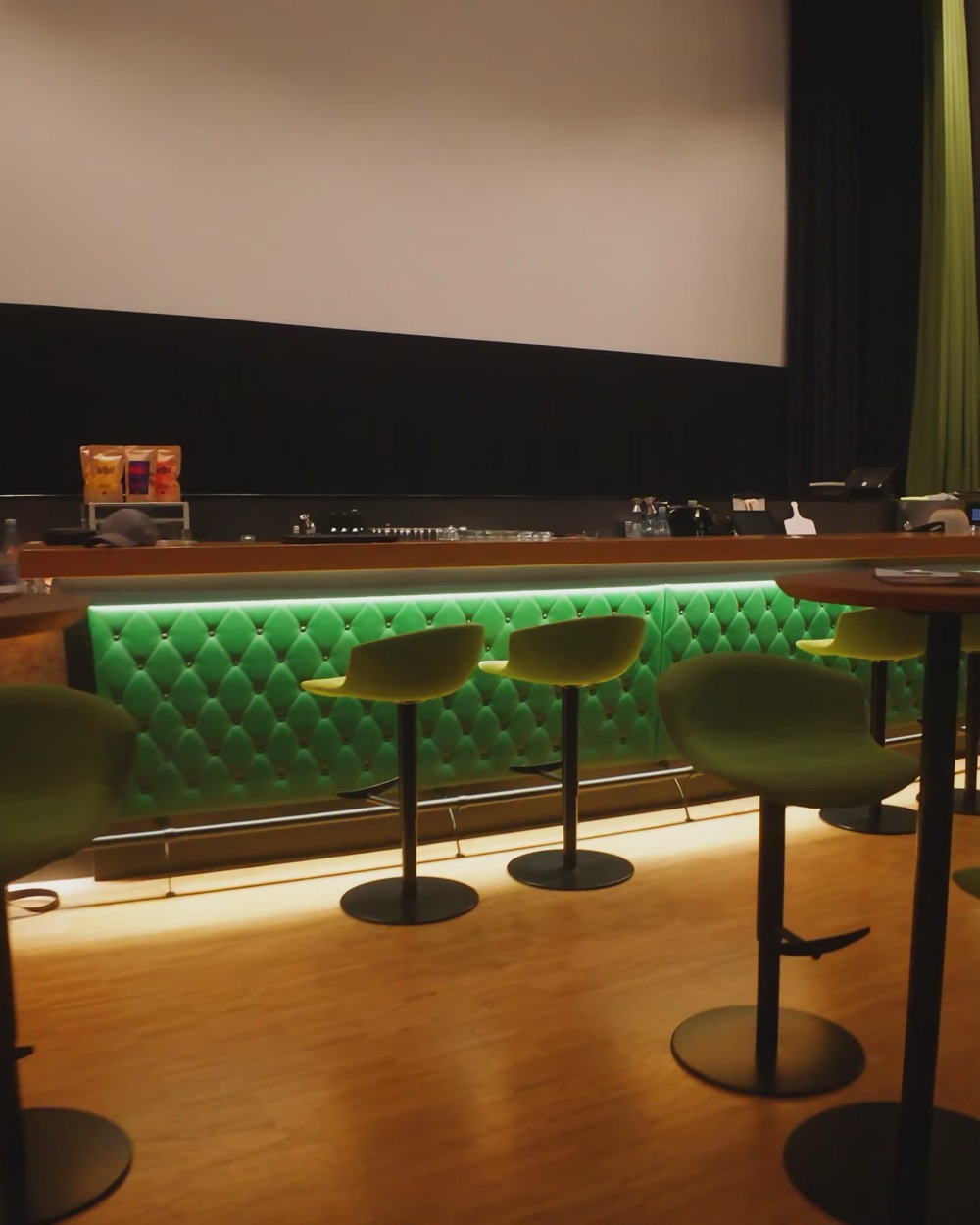 Die beleuchtete Bar im Kinosaal mit Barhockern
